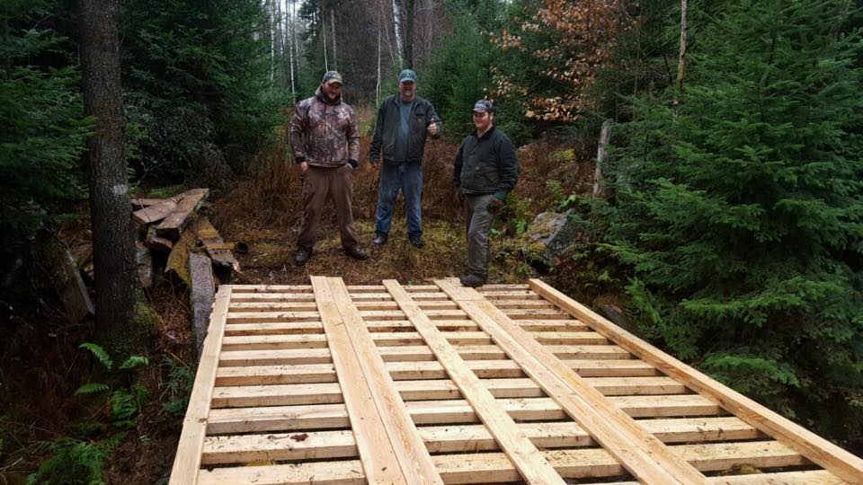 WRR volunteers standing near a freshly built bridge on the trail.